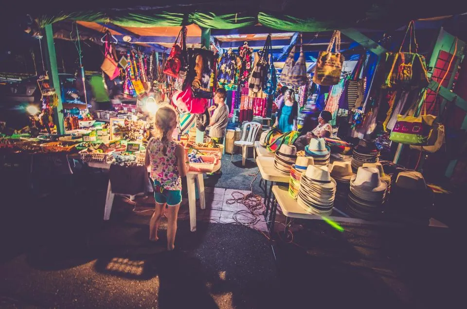 Mercado iluminado con puestos de artesanías y productos